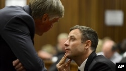 FILE - Oscar Pistorius (r) speaks with defense lawyer Brian Webber in court in Pretoria, South Africa. 
