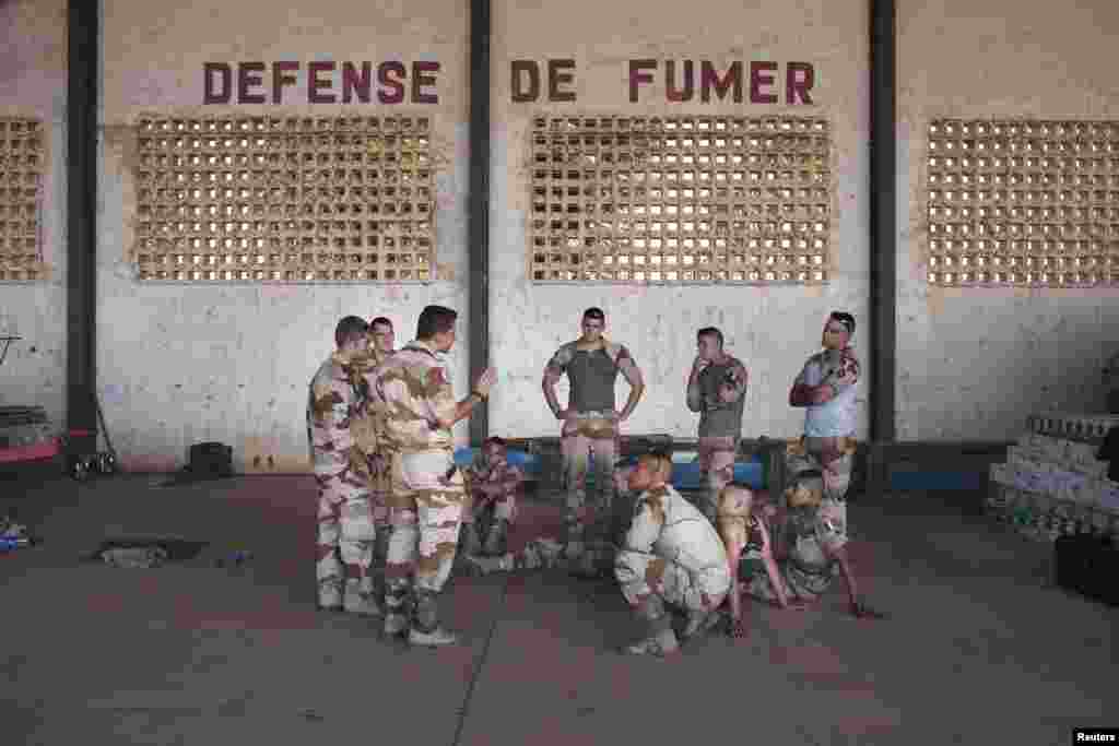 French soldiers listen to instructions in a hangar at the Malian army air base in Bamako, January 14, 2013.