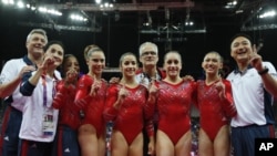 US gymnasts celebrate gold medal win with coaches after women's team final at 2012 Summer Olympics, July 31, 2012