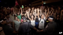 Israeli activists raise their hands during a social protest in Tel Aviv, June 24, 2012.