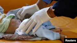 A nurse checks a boy at a cholera treatment center at the al-Sabeen hospital in Sanaa, Yemen, Oct. 3, 2018. 