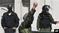 A demonstrator chants slogans in front of the Bahraini Embassy in Tehran, Iran as he covers his face in the style of Palestinian militants, in a protest against Saudi and Bahraini leaders to condemn the crackdown on the Bahraini opposition, April 15, 2011