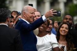President Joe Biden poses for a selfie with guests after delivering a speech during Independence Day celebrations on the South Lawn of the White House, in Washington, July 4, 2021.