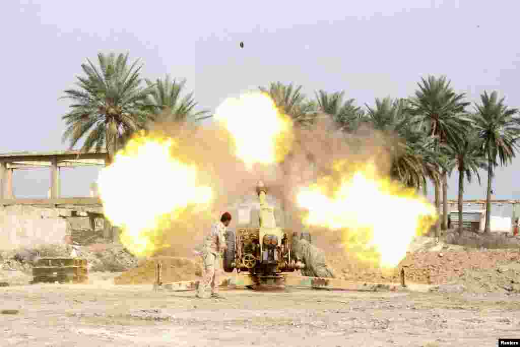 19일 이라크 바그다드 남쪽에서 무력 충돌이 발생한 가운데, 정부군이 알카예다 연계 무장단체 ISIL에 대포를 쏘고 있다.