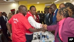 FILE - Jubilee Coalition presidential candidate Uhuru Kenyatta, 2nd left, accompanied by his running mate William Ruto, left, meets with Independent Electoral and Boundaries Commission (IEBC) members in Nairobi, Kenya, May 29, 2017.