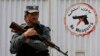 Seorang polisi Afghanistan berdiri di pagar Cure Hospital setelah tiga orang Amerika tewas, Kabul, 24 April 2014.