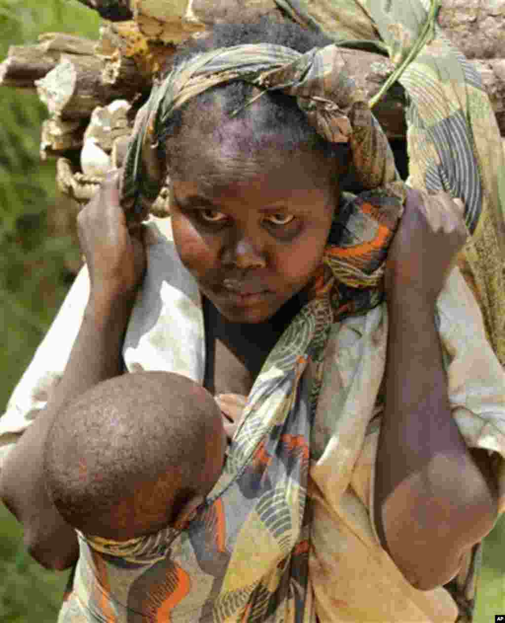 A woman carries a child and food stuff on a main road outside the small village of Walikale, Congo, Thursday, Sept. 16, 2010. According to aid workers, crimes like rape have been used as a brutal weapon of war in Congo, where conflicts based on tribal li