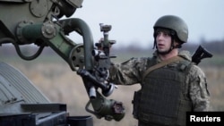 A service member of the Ukrainian Armed Forces stands next to a BM-21 "Grad" multiple rocket launcher during tactical military exercises at a shooting range in the Kherson region, Ukraine, Jan. 19, 2022.