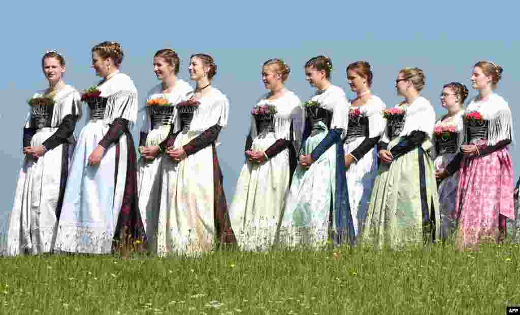 Women dressed in Bavarian clothes take part in the traditional Corpus Christi procession near the village of Wackersberg, Germany.