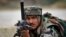 An Indian Army soldier takes position during an encounter with armed suspected militants at Pindi Khattar village in Arnia border sector, 43 kilometers (27 miles) south of Jammu, India, Nov. 27, 2014. 