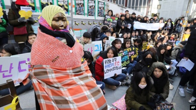 在韩国首尔日本大使馆前的一次集会上，学生们聚集在一个“慰安妇”雕像附近。 （2017年1月11日美联社资料照）