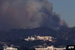 Asap dari Kebakaran Palisades mengepul di atas Museum Getty di Los Angeles, California pada 11 Januari 2025. (Foto: AFP)