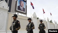 Cambodian government security forces walk in front of the Council of Ministers building as they patrol along a street ahead of the 21st ASEAN Summit and other related summits in Phnom Penh, November 13, 2012.