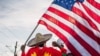 A man holds up the U.S. flag as members of the Oromo community march in protest over the death of musician and revolutionary Hachalu Hundessa, July 8, 2020, in St. Paul, Minnesota. 