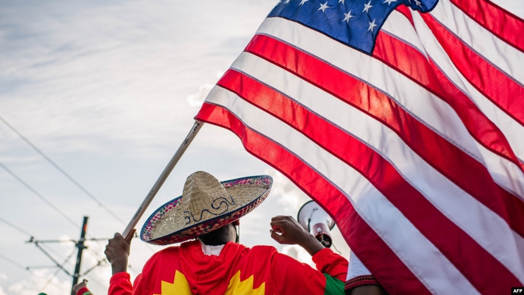 A man holds up the U.S. flag as members of the Oromo community march in protest over the death of musician and revolutionary Hachalu Hundessa, July 8, 2020, in St. Paul, Minnesota. 