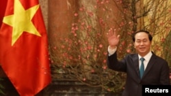 FILE - Vietnam's President Tran Dai Quang waves his hand to the media as he waits for arrival of Japan's Prime Minister Shinzo Abe at the Presidential Palace in Hanoi, Vietnam, Jan. 16, 2017. 