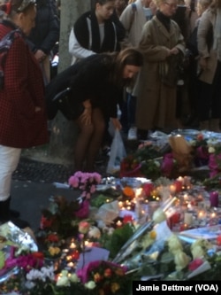 Visitors lay flowers at a memorial near La Belle Equipe bar in the rue de Charonne, where one of Friday's attacks occurred, in Paris, Nov. 15, 2015.