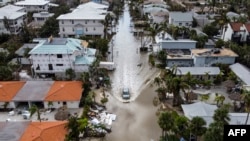 Vozilo prolazi kroz poplavljenu ulicu nakon uragana Milton, u Siesta Key, Florida, 10. oktobra 2024.