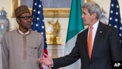 Secretary of State John Kerry gestures while he and Nigerian President Muhammadu Buhari make statements prior to a working lunch at the State Department in Washington, July 21, 2015.