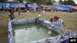 Seorang ibu mengambil air bersih dari tempat penyimpanan air di tempat pengungsian di Lombok setelah gempa 6,4 SR pada Minggu, 29 Juli 2018. Berdasarkan data BNPB, 16 orang meninggal dunia akibat gempa dan ratusan terluka.