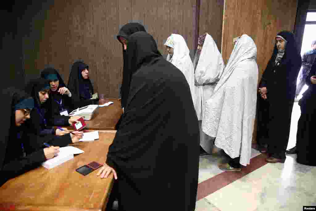 Women line up before they cast their vote during parliamentary elections at a polling station in Tehran, Iran.