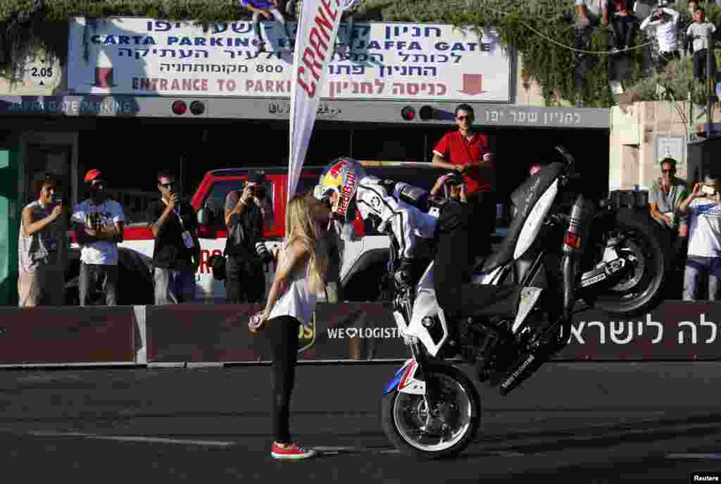 Pembalap Chris Pfeiffer melakukan aksi dengan sepeda motor BMW-nya sambil mencium seorang perempuan, selama &#39;road show&#39; di kota Yerusalem.