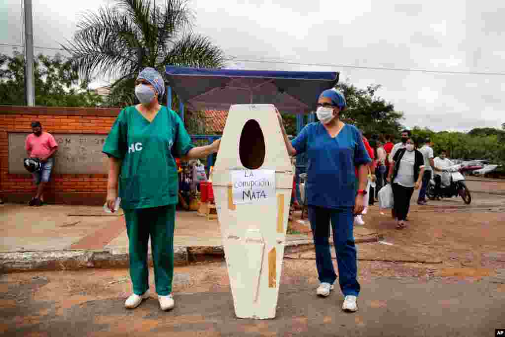 Nurses who work at the Hospital de Clinicas hold up an empty coffin with the Spanish message "Corruption kills" before the start of a protest demanding more medical supplies, outside their public hospital in San Lorenzo, Paraguay.