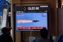 People watch a TV screen showing a news program reporting about North Korea's missiles with a file image at the Seoul Railway Station in Seoul, South Korea, Tuesday, April 14, 2020.