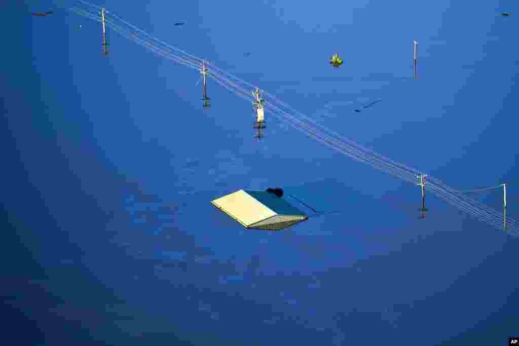 The roof of a structure is visible as floodwater covers large areas northwest of Sydney, Australia.