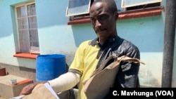 Adrian Munjere, who sustained fractures on his right hand during post-election clashes between security forces and protesters Aug. 1, displays his doctor’s report in Harare, Oct. 17, 2018. 