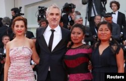 Director Alfonso Cuaron with actors Yalitza Aparicio, Nancy Garcia and Marina de Tavira, pose on the red carpet upon arriving at the 75th Venice International Film Festival for the screening of the film "Roma," Aug. 30, 2018.