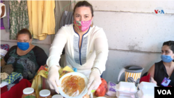 Una exilidada nicaragüense en Costa Rica muestra un plato típico de su país como parte de las celebraciones navideñas. [Foto: Armando Gómez/VOA].