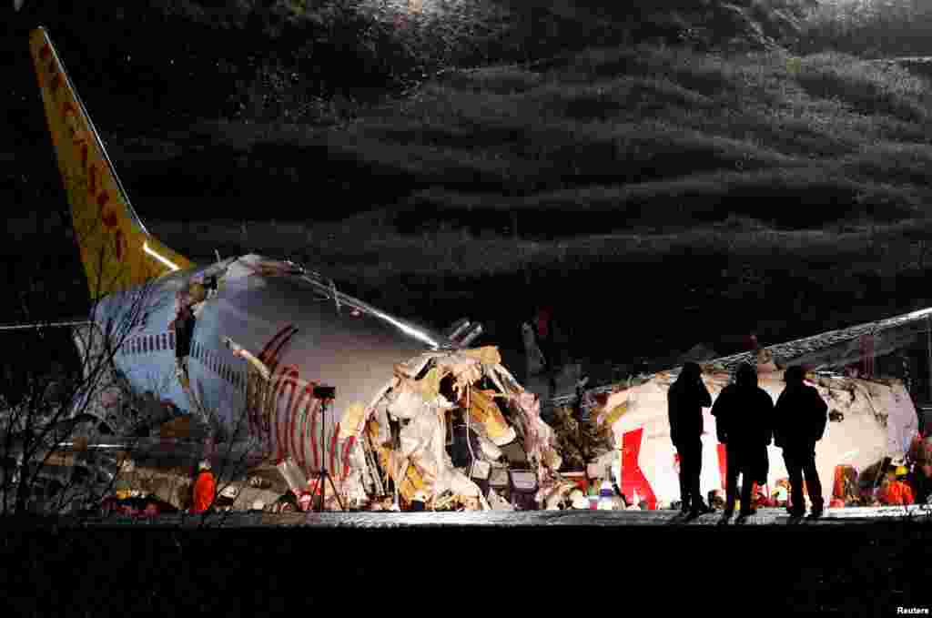 Police officers inspect the Pegasus Airlines Boeing 737-86J plane, that overran the runway during landing and crashed, at Istanbul&#39;s Sabiha Gokcen airport, Turkey.