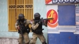 FILE—Police take cover during an anti-gang operation at Portail neighborhood in Port-au-Prince, Haiti, February 29, 2024