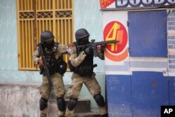 FILE—Police take cover during an anti-gang operation at Portail neighborhood in Port-au-Prince, Haiti, February 29, 2024.