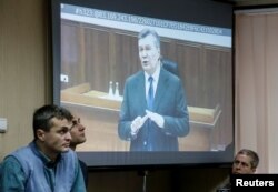 FILE - Former Ukrainian pesident Viktor Yanukovych testifies via a video link from Russia on a courtroom screen in Kyiv, Ukraine, Nov. 28, 2016. Widely considered corrupt and a crony of Russian President Vladimir Putin, he was ousted in a popular uprising that culminated with Yanukovych fleeing Ukraine for Russia in February of 2014.