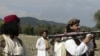 Armed militants of Tehreek-e-Taliban Pakistan (TTP) pose for photographs next to a captured armored vehicle in the Pakistan-Afghanistan border town of Landikotal on November 10, 2008, after they hijacked supply trucks bound for Afghanistan.