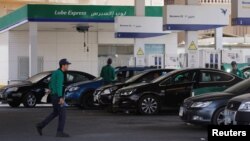 Workers fill cars as people wait in their cars at Emarat petrol stations after an increase in fuel prices in Cairo, Egypt, June 30, 2017. For the third time sine 2015, Egypt has raise fuel prices.