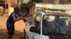 Un chauffeur de taxi lave son véhicule dans une rue de Niamey, le 16 mars, 2016. (VOA/Bagassi Koura)