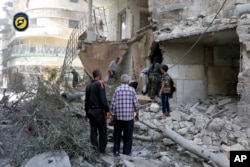 FILE - In this photo provided by the Syrian Civil Defense 'White Helmets,' rescue workers work the site of airstrikes in al-Mashhad neighborhood in the rebel-held part of eastern Aleppo, Sept. 21, 2016.