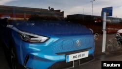 FILE - An EV from MG, a brand of Chinese state-owned carmaker SAIC, is seen through the glass of a car showroom in Santander, Spain, June 13, 2024.