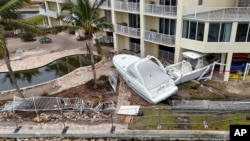 Beberapa perahu tampak terdampar di area apartemen akibat terbawa banjir yang disebabkan oleh badai Helene di St. Petersburg, Florida, pada 28 September 2024. (Foto: AP/Mike Carlson)