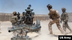 FILE - New Jersey Army National Guard artillerymen perform a live fire exercise with their Iraqi counterparts in western Iraq, July 31, 2024.