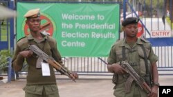 Des policiers armés surveillent un bureau de vote pendant des élections à Lusaka en Zambie, le 21 janvier 2015.