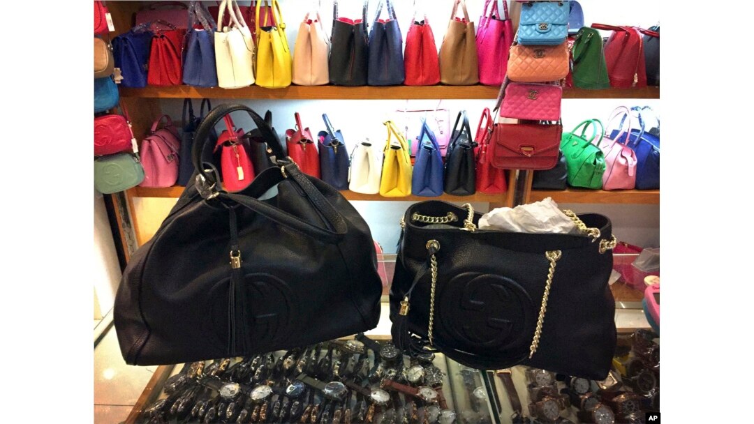 FILE - Counterfeit branded bags appear on display in a room hidden from the public area of a popular shopping mall in Beijing, China, March 11, 2015.