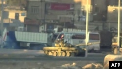 An image grab taken from a video uploaded on YouTube on August 22, 2012 allegedly shows a Syrian army tank deploying the the Nahr Aishe neighborhood of Damascus, August 22, 2012. 