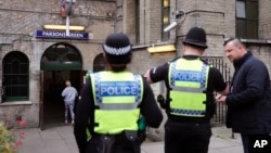 Polisi London siaga di depan pintu masuk stasiun kereta bawah tanah Parsons Green, lokasi terjadinya serangan bom di London pada hari Jumat 15/7. 
