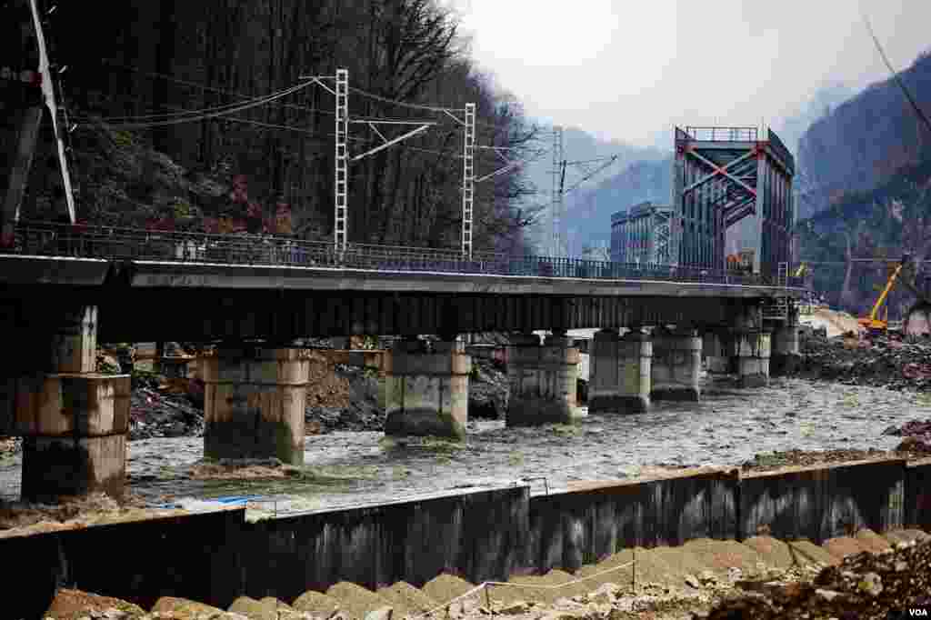 The concrete pylons of a railroad bridge through the once clear waters of the Mzimta River. Once a magnet for rafters and spawning salmon, the river is now brown and routed through many concrete channels. (V. Undritz for VOA)