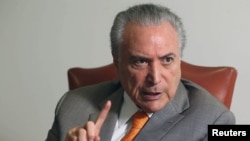 FILE - Brazil's President Michel Temer, gestures during an interview with Reuters at his office in Brasilia, Brazil, Jan. 16, 2017.
