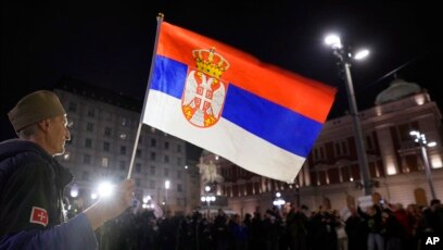 Një burrë mban një flamur serb gjatë një proteste në Beograd, Serbi (28 nëntor 2021)